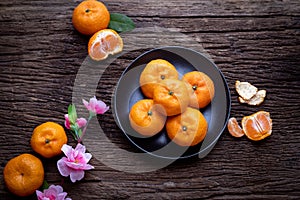 Orange fruit and pink cherry blossom on wood table. concept of celebration Chinese new year festival background