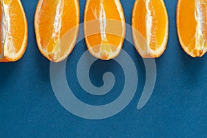 Orange fruit slices on blue background, healthy food concept, empty space for text