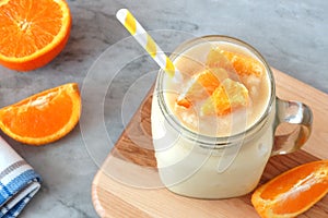 Orange fruit smoothie in a mason jar with straw
