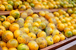 Orange fruits soiled organic stacked on wood crate in grocery