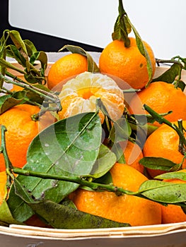 Orange fruits in wooden box on dark stone table. Heap of oranges in box. Fresh juicy orange