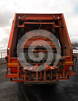 orange garbage truck, rear view.