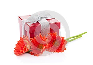 Orange gerbera flowers and red gift box