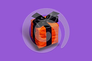 Orange gift box isolated on purple background