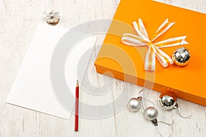 Orange gift box with silver christmas baubles