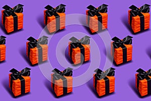 Orange gift boxes tied with a black ribbon on a purple background
