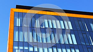 Orange and glass wall of corporate building. Modern architecture. Skyscraper geometry. Business office park. Urban real estate.