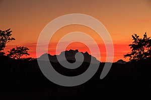 The orange glow of sunset creating a silhouette of the mountains of Torres del Paine National Park