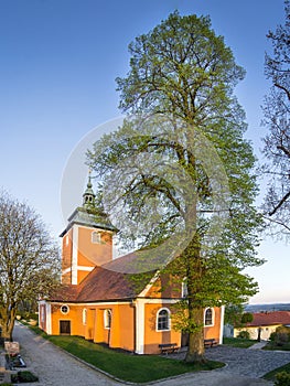 Orange, glowing church under a blue sky