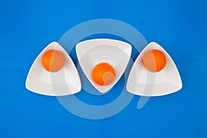 Orange golf balls on the triangular ceramic bowls