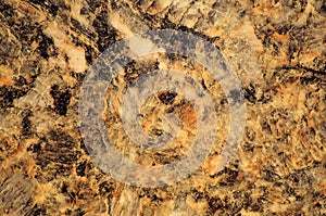 Orange granite with black blotches, close-up of polished natural stone surface