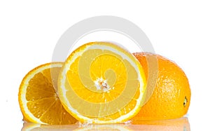 Orange and grapefruit in a spray of water on a white background