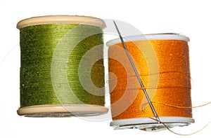 Orange and green bobbins of thread