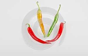 Orange, green and red sweet chili peppers smiling.