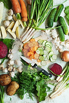 Orange and green veggies and roots composition on a dark slate t