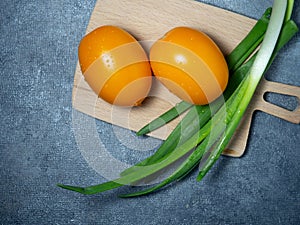 Orange greenhouse tomatoes on the kitchen board. Tomatoes with chives