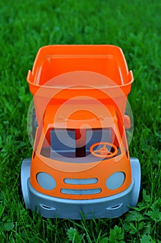 Orange and grey toy car on green grass