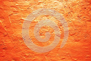 Orange grunge texture background. Painted wall. Bright saturated color. Rough surface plaster. Gradient.