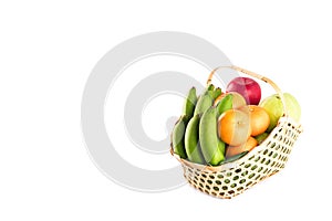 Orange, guava, banana and apple in wicker basket on white background fruit health food isolated