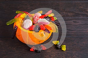 Orange halloween treak or treat container with candies