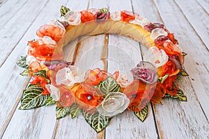 Orange handmade flower circle for newborn babies lying on wooden