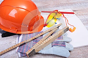 Orange hard hat, earplug, safety glasses and gloves for work. Earplug to reduce noise on a white background.