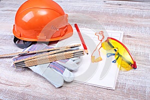 Orange hard hat, earplug, safety glasses and gloves for work. Earplug to reduce noise on a white background.