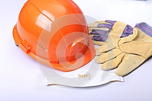 Orange hard hat, goggles, protective mask, respirator and safety gloves on a white background.