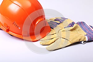 Oranžový tvrdý klobouk ochranné brýle rukavice na bílý 