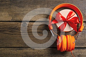 Orange headphones music audio, box with ribbon bow gift