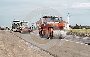 Orange Heavy Vibration roller compactor at asphalt pavement works for road repairing. Working on the new road