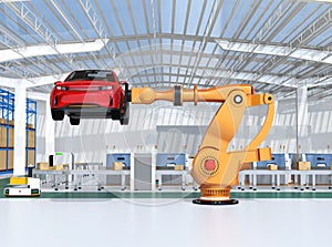 Orange heavyweight robotic arm carrying red SUV in the assembly factory