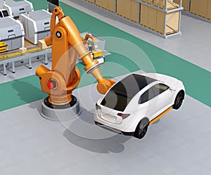 Orange heavyweight robotic arm carrying white SUV in the assembly factory