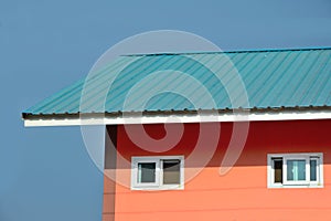 Orange house with blue roof blue sky backgroun