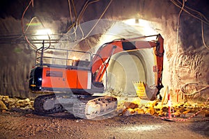 Orange Hydraulic Excavator in Concrete Tunnel Construction