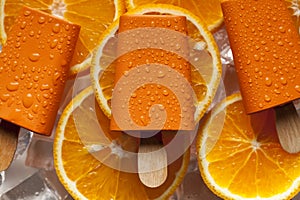 Orange ice lolly on ice cubes and fruits