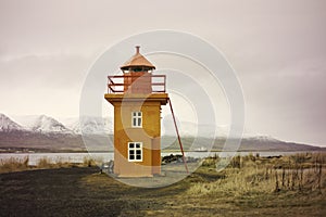 Orange Icelandic Lighthouse against mountain background