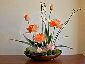 ikebana de flores de loto naranja generative AI photo