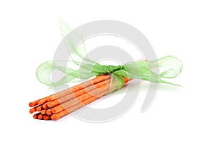 Orange incense sticks tied with green tie on white