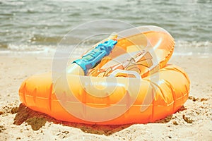 Orange inflatable swimming circles and children`s water gun