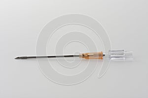 Orange intravenous cannula 14 G on white background, external diameter 2,1 mm, used in trauma, blood transfusion, surgery, ascites