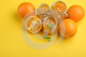 Orange jam in a glass jar on a yellow background. With empty space for writing