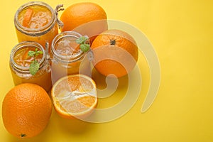 Orange jam in a glass jar on a yellow background. With empty space for writing