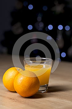 Orange juice on a drinking glass with fresh oranges fruit on a wooden table