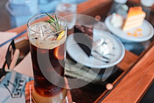 Orange juice espresso with ice and the background is a blurred cake.