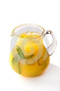 Orange juice with fruit pieces in a jug on an isolated white background