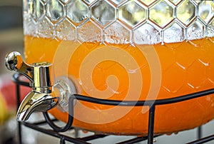 Orange juice in glass dispensor at breakfast catering.