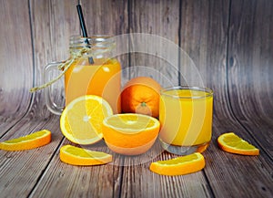 Orange juice in the glass jar and fresh orange fruit slice on wooden table - Still life glass juice on dark background