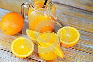 Orange juice in the glass jar and fresh orange fruit slice on wooden table - Still life glass juice on wood background