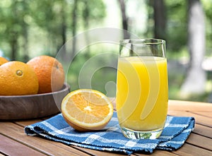 Orange juice in glass with oranges